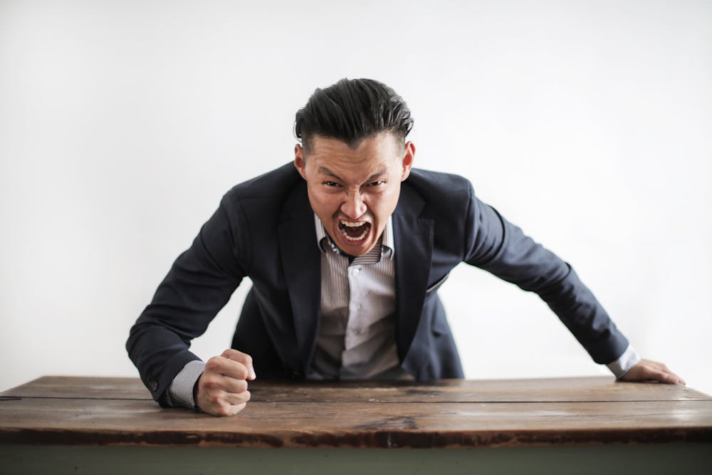 Mann schlägt wütend mit Faust auf Tisch - Foto von Andrea Piacquadio